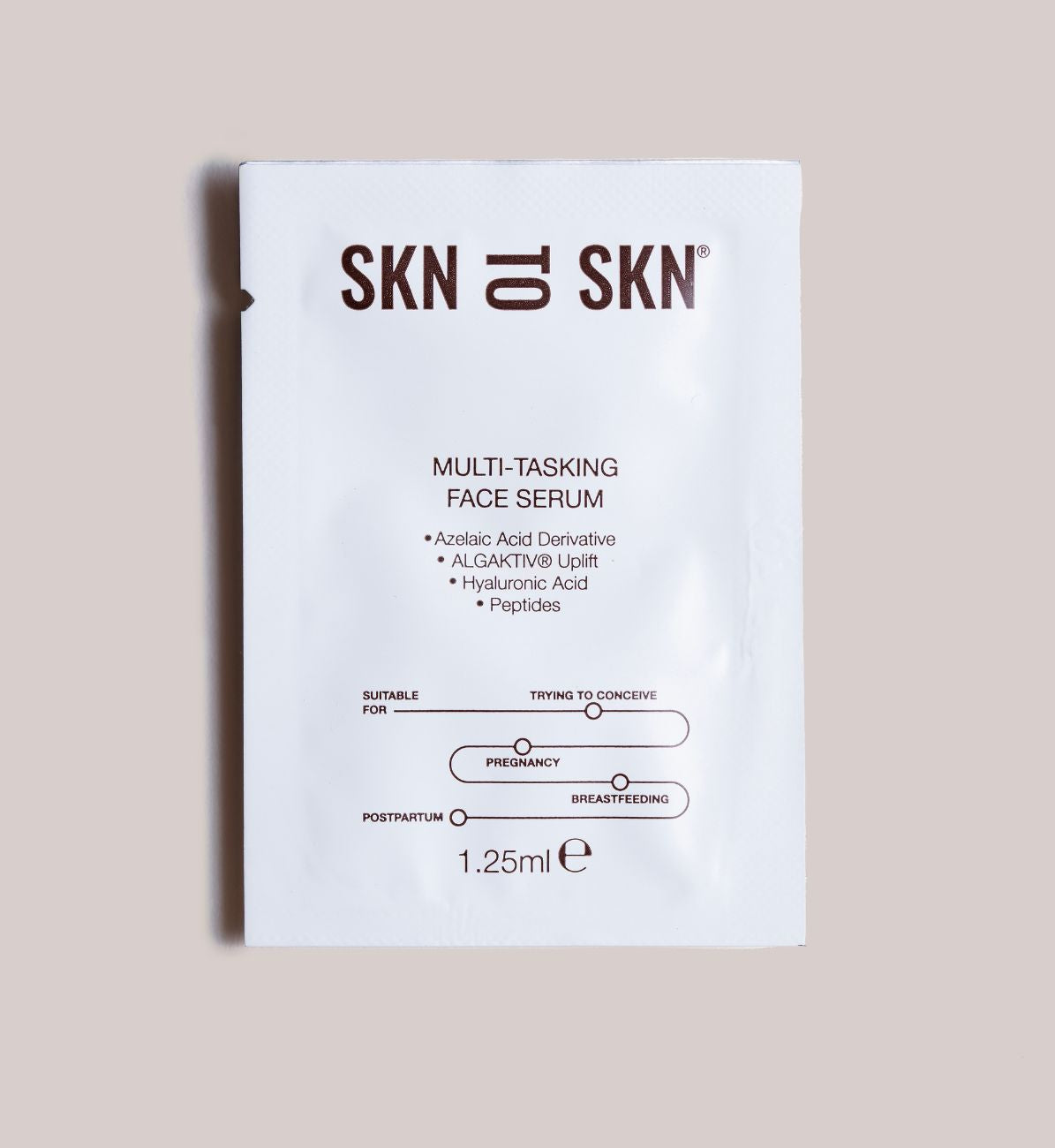 SKN multi-tasking face serum packaging on a beige background